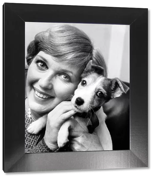 Katie Boyle with a mongrel puppy dog at Battersea dogs home in London