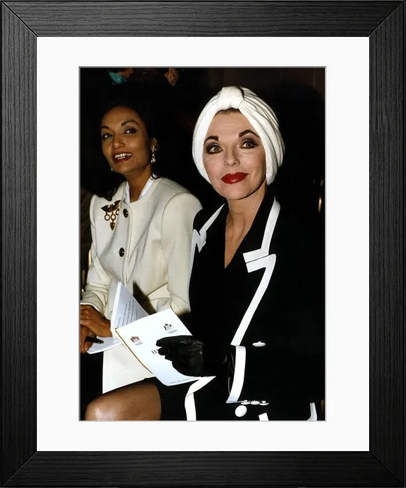 Framed Print : Joan Collins Actress and Shakira Caine sit side by side at a fashion show in London