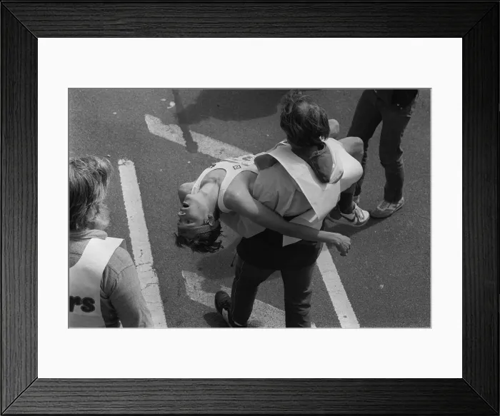 Framed Print : London Marathon one man carrying another in his arms after the race 1984 Framed Print : London Marathon one man carrying another in his arms after the race 1984