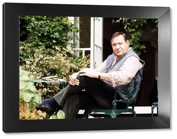Michael Elphick Actor sitting in chair at home in garden