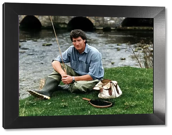 Jeremy Paxman tv presenter of Newsnight and journalist with his fishing gear on riverbank