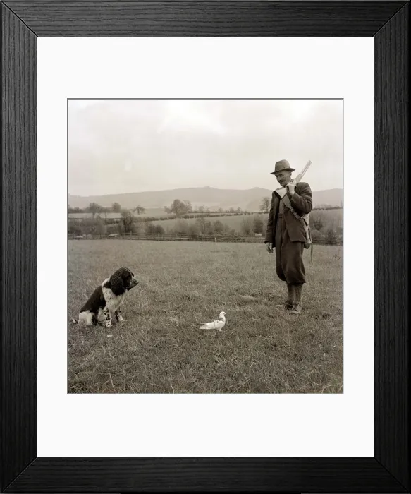 Framed Print : A farmer with his dog watching a bird in front of them circa 1950s Framed Print : A farmer with his dog watching a bird in front of them circa 1950s