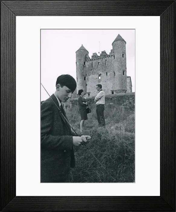 Framed Print : A fisherman baits his line in the shadow of thecastlweat Kouneskelly circa 1950 Framed Print : A fisherman baits his line in the shadow of thecastlweat Kouneskelly circa 1950