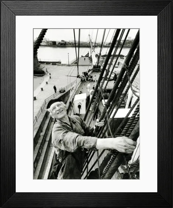 Framed Print : A man of the sea perched high above the deck of the Cutty Sark returns the wave to two Framed Print : A man of the sea perched high above the deck of the Cutty Sark returns the wave to two