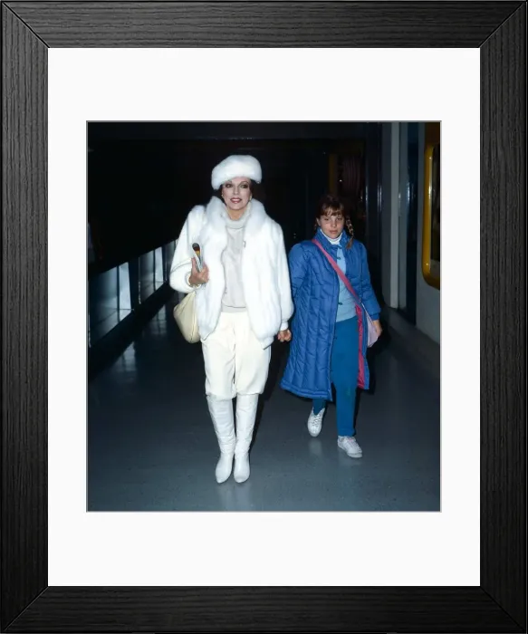 Framed Print : Joan Collins actress leaves Heathrow Airport with daughter Katy, holding hands Framed Print : Joan Collins actress leaves Heathrow Airport with daughter Katy, holding hands