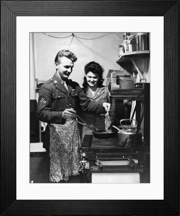 Framed Print : American soldier shows his English wife how he likes his steak done, circa 1944
