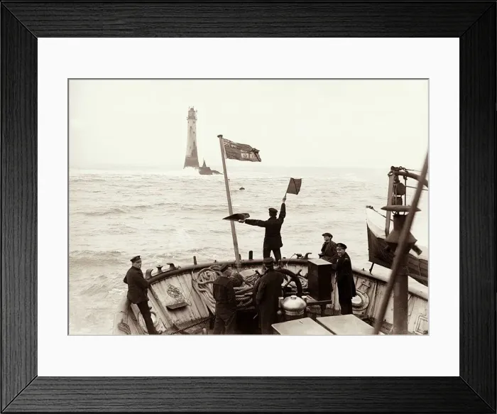 Framed Print : A crewman semaphores a signal from the Trinity House tender to the Wolf Rock Lighthouse