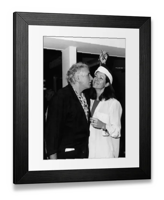 Framed Print : Jenny Seagrove Actress with Film Director Michael Winner kissing under a mistletoe