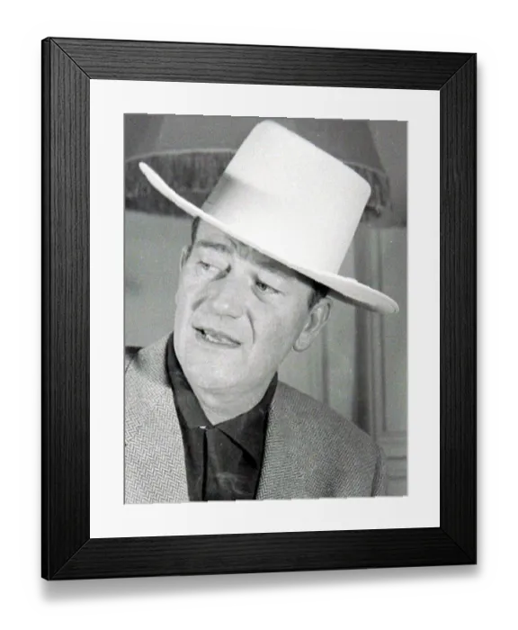 Framed Print : John Wayne, American film actor, arrives in London for the opening of his film