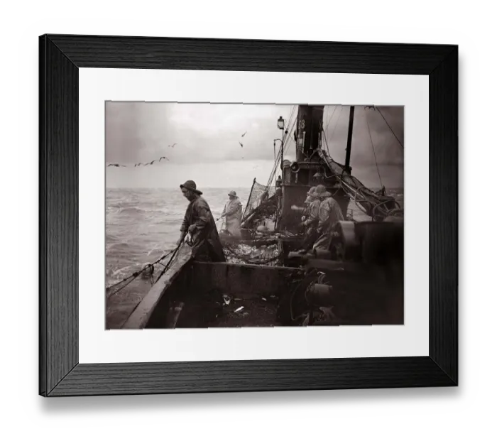 Framed Print : The crew of a Yarmouth Herring boat pull in their catch on a storm tossed North Sea
