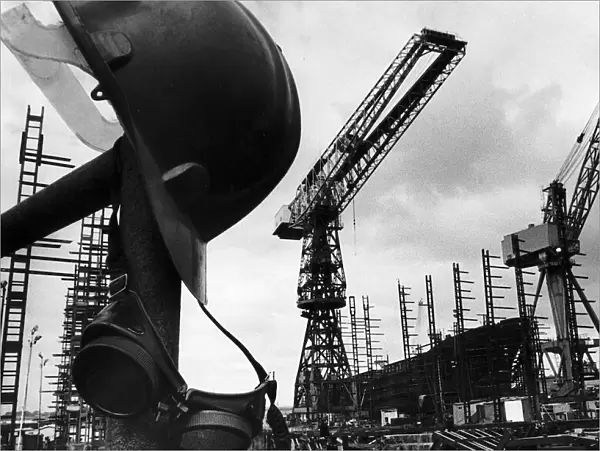 A helmet hanging with welders goggles amongst the empty cranes after the closure of Govan