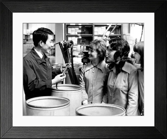 Framed Print : Japanese technician Tadashi Saeki talks with the three machine operators at a Japanese