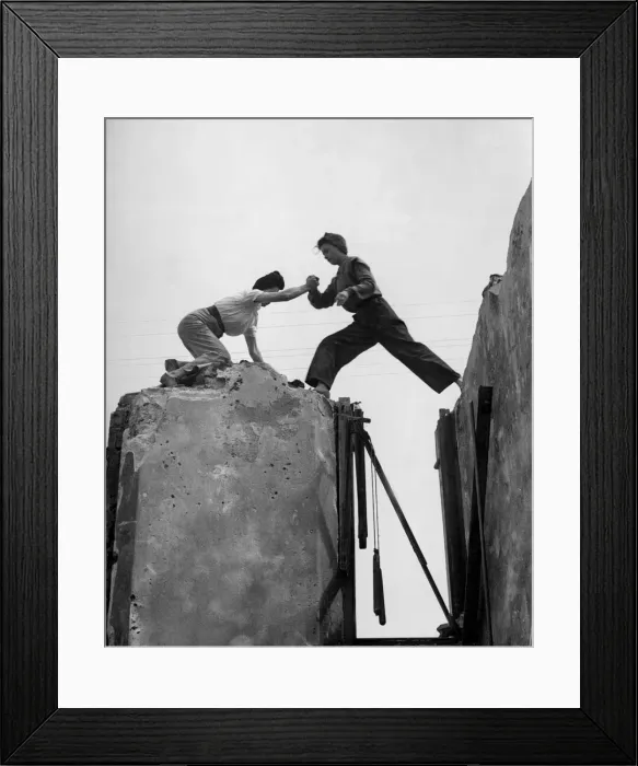 Framed Print : High up on the tottering wall, Lydia Walker steps across the gap aided by Betty Baker Framed Print : High up on the tottering wall, Lydia Walker steps across the gap aided by Betty Baker