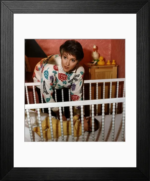 Framed Print : Anne Diamond TV Presenter Putting baby in to cot Framed Print : Anne Diamond TV Presenter Putting baby in to cot