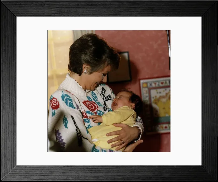 Framed Print : Anne Diamond cuddles tiny Clemency one of the babies used in the ad Framed Print : Anne Diamond cuddles tiny Clemency one of the babies used in the ad