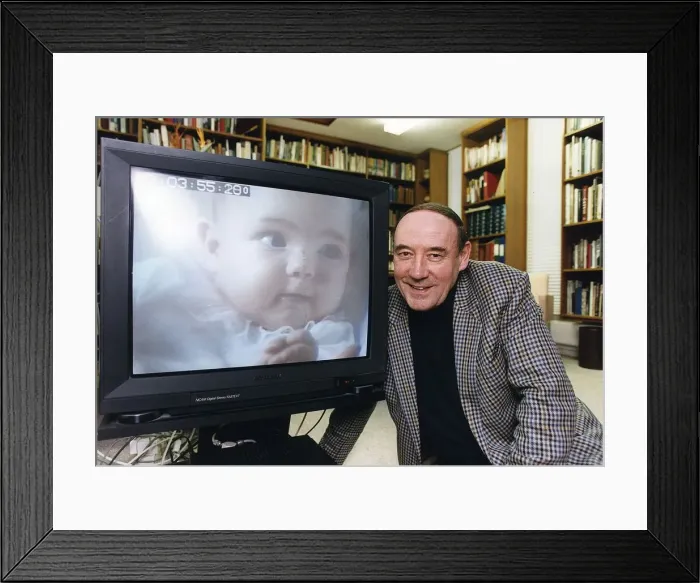 Framed Print : Desmond Morris anthropologist tv presenter baby watching at his home in Oxford Dbase