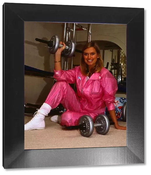 TV presenter Anneka Rice February 1986 sitting on floor holding weights wearing