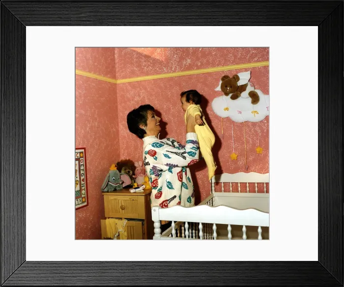 Framed Print : Anne Diamond cuddles tiny Clemency one of the babies used in the ad DBase