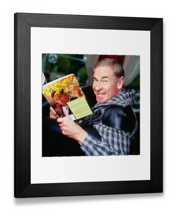 Framed Print : Stanley Baxter holding book with picture of himself on it September 1986 Framed Print : Stanley Baxter holding book with picture of himself on it September 1986
