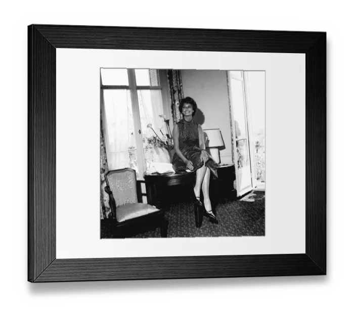 Framed Print : Italian actress Sophia Loren sitting on her desk in her hotel room during the Cannes film