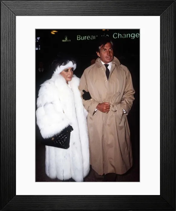 Framed Print : Elizabeth Taylor Jan 1987 wearing white fur coat at Heathrow Airport with George Framed Print : Elizabeth Taylor Jan 1987 wearing white fur coat at Heathrow Airport with George