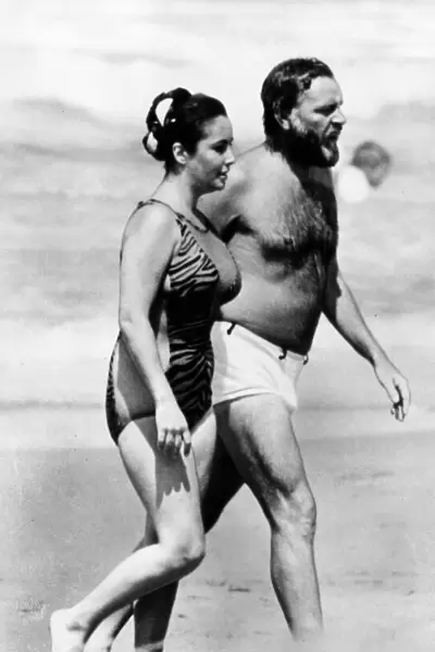 Actress Elizabeth Taylor and husband Richard Burton on the beach