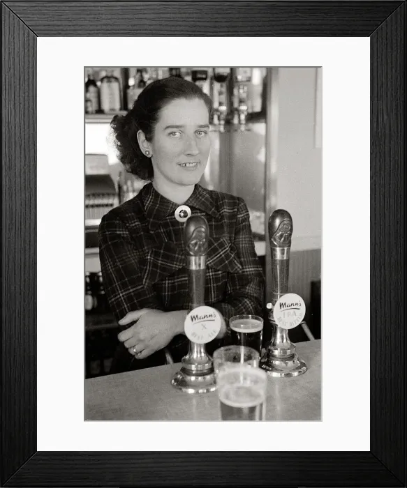 Framed Print : The barmaid at The Chimes Lansbury Public House stands behind the bar beside the beer Framed Print : The barmaid at The Chimes Lansbury Public House stands behind the bar beside the beer