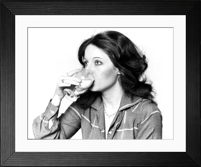 Framed Print : Woman drinking a cocktail from a wine glass September 1977 Framed Print : Woman drinking a cocktail from a wine glass September 1977