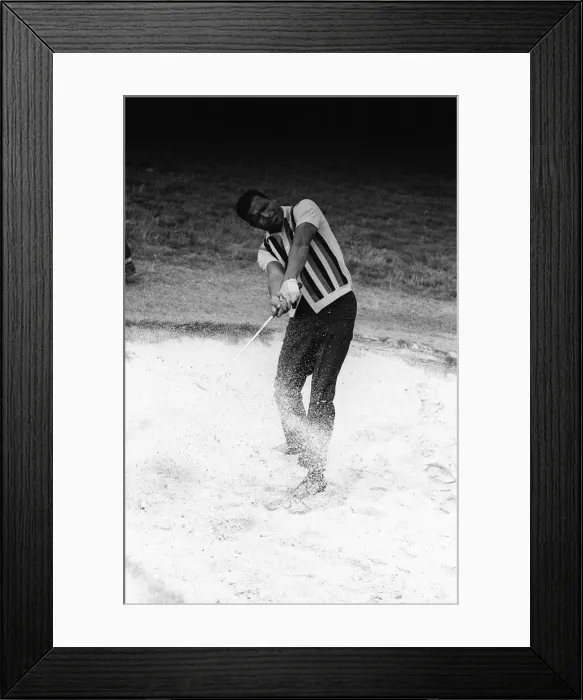 Framed Print : Boxer Sugar Ray Robinson relaxing with a game of golf trying to get the ball out of