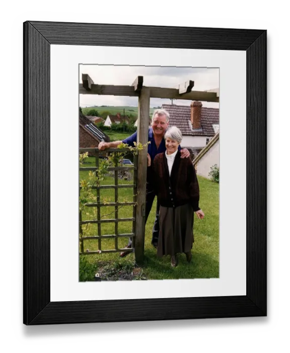 Framed Print : George Baker standing next to a gate with wife louie Framed Print : George Baker standing next to a gate with wife louie