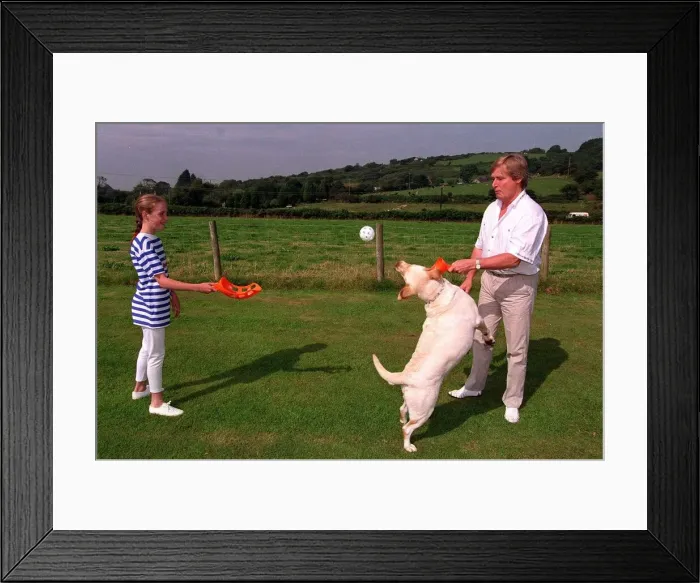 Framed Print : William Roache Actor playing with his daughter and their dog in the back garden Framed Print : William Roache Actor playing with his daughter and their dog in the back garden