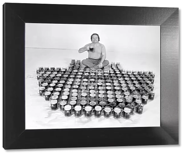 Man sitting in front of two hundred pints of beer