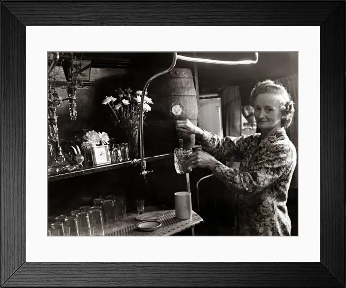 Framed Print : Mrs Allen pours a pint from the barrell circa 1948