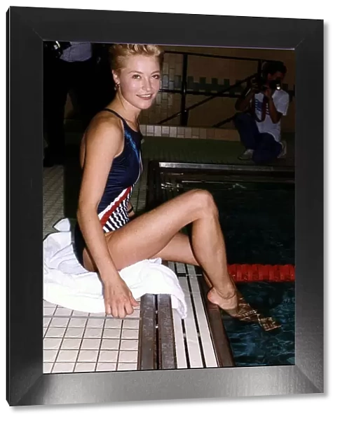 Amanda Donohoe British Actress sitting by a swimming pool with her feet in the water