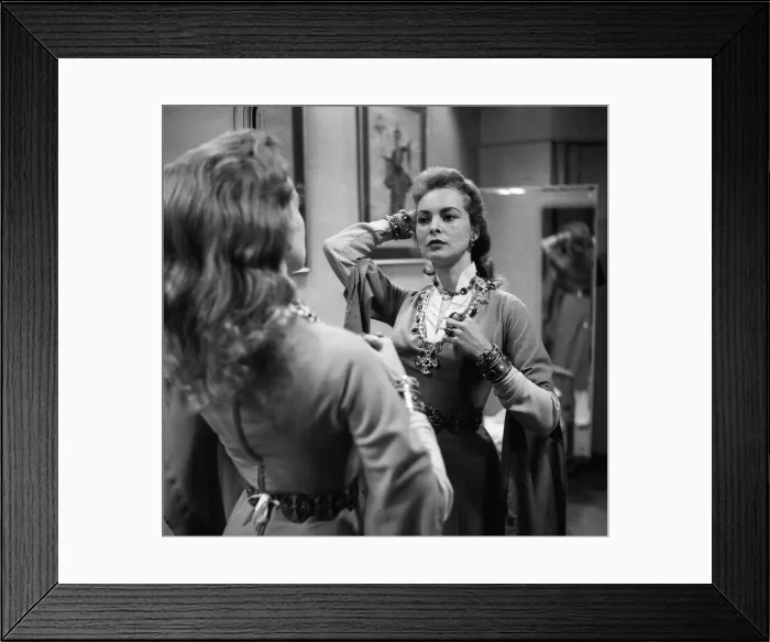 Framed Print : Actress Janet Leigh looks at her reflection in the mirror at a costume fitting for