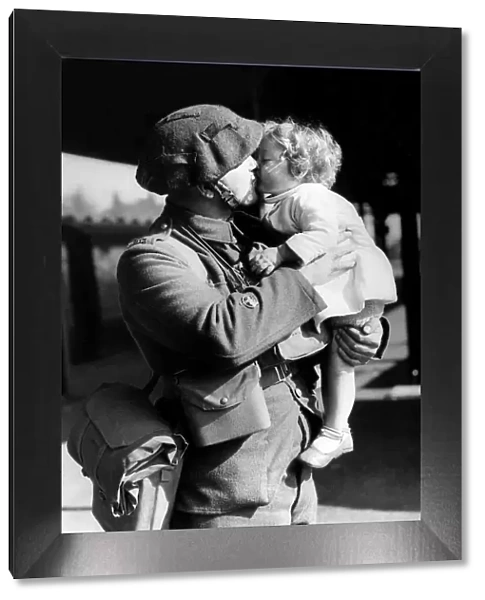 An army soldier kisses his child good bye - October 1939 as he leaves for war