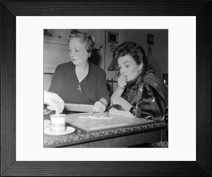 Framed Print : Actress Jean Simmons, right, with her former teacher Ada Foster playing a game of
