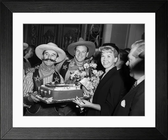Framed Print : Actress Doris Day is presented with a cake by a couple of cowboys April 1955