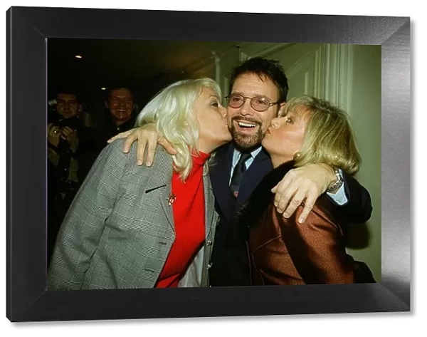 Singer Cliff Richard receives a kss on the cheek from Eastenders actress Wendy Richard