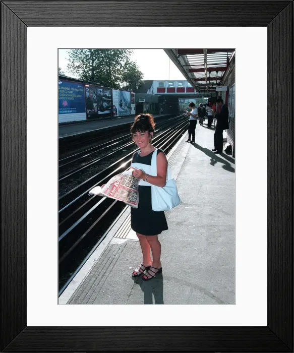 Framed Print : Maria Smedley actress reading copy of Daily Mirror Newspaper while standing Framed Print : Maria Smedley actress reading copy of Daily Mirror Newspaper while standing