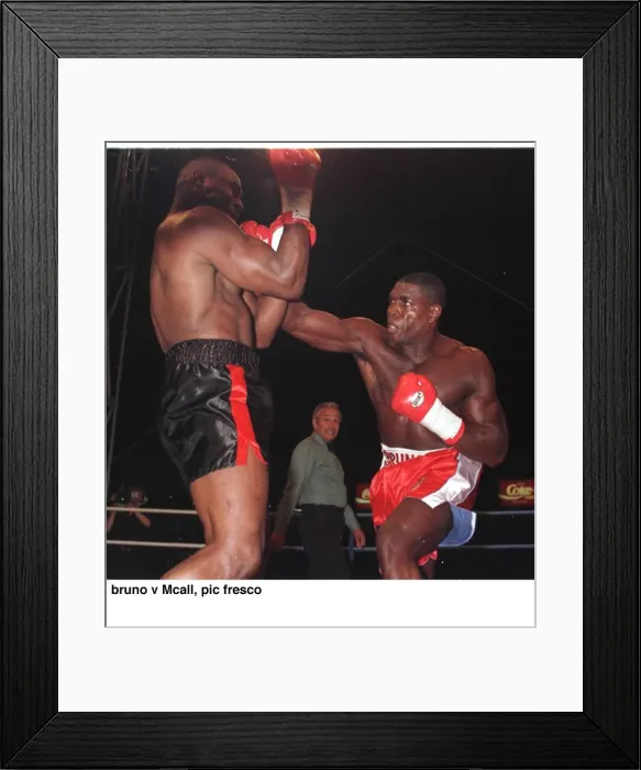 Framed Print : Frank Bruno strikes Oliver McCall with a right hook during their fight for Framed Print : Frank Bruno strikes Oliver McCall with a right hook during their fight for