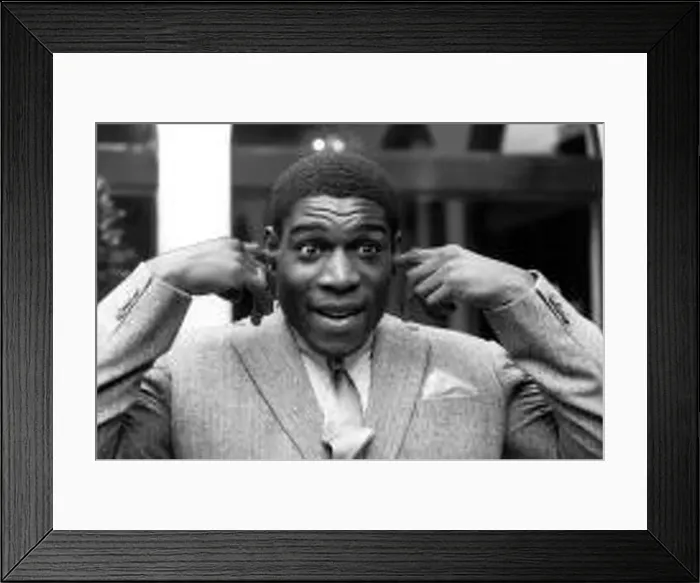 : Frank Bruno stands with his hands raised and his fingers in his ears : Frank Bruno stands with his hands raised and his fingers in his ears