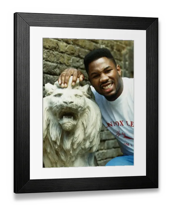Framed Print : Lennox Lewis Boxer with his hand on a statue of a Lion