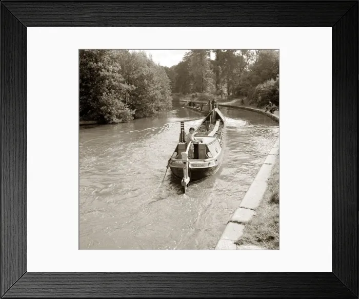 Framed Print : People steering their narrow boats along the canal, with People fishing along