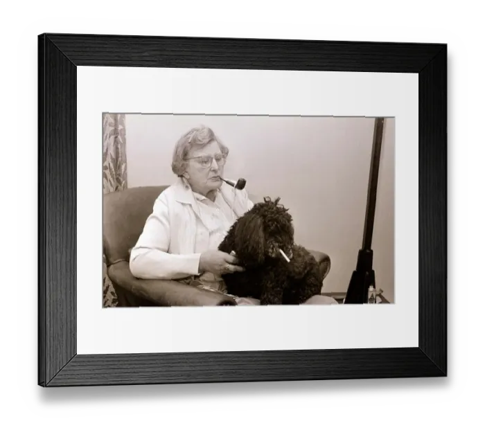 Framed Print : The Poodle who eats cigarettes An old lady smoking a pipe with her pet poodle who