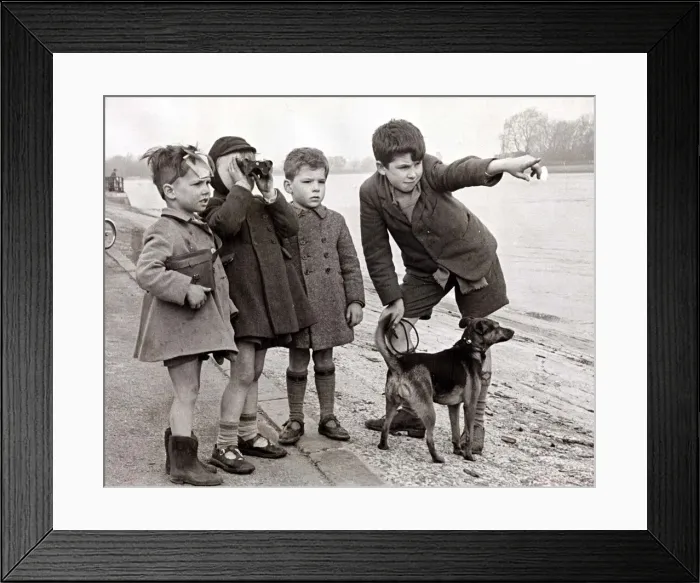 Framed Print : A group of children look to the distance using a pair of binoculars