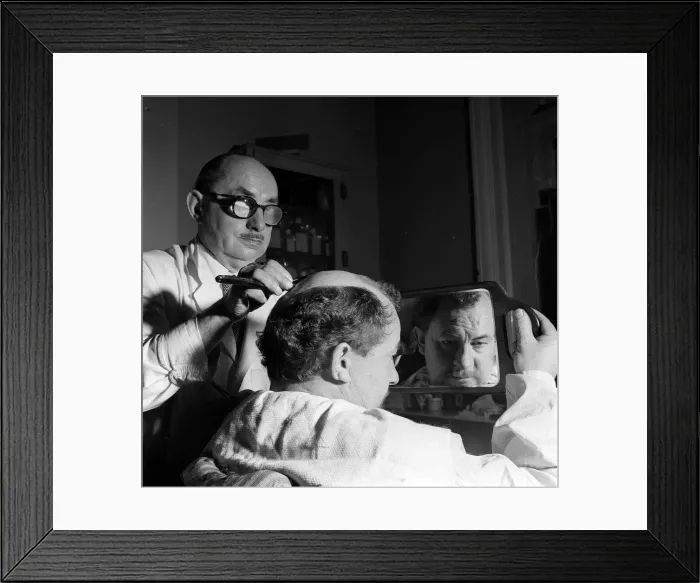 Framed Print : Leo McKern looks at his reflection in a mirror after getting a special hair do for a