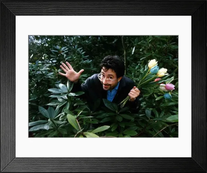 : Ben Elton comedian writer actor standing in between plants holding a bunch of Tulips : Ben Elton comedian writer actor standing in between plants holding a bunch of Tulips