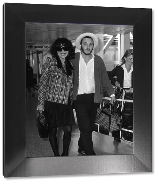 Joan Collins with her son Sacha aged 22 arriving from Los Angeles at Heathrow airport