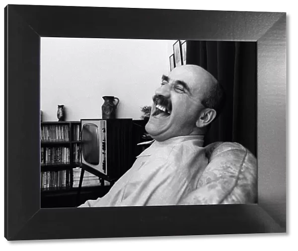 Warren Mitchell has a laugh at home